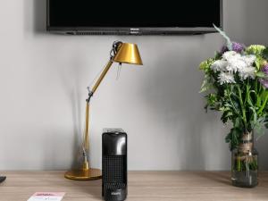 a lamp on a table next to a vase of flowers at Numa Prague Root in Prague