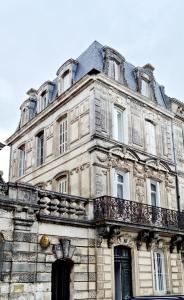 um antigo edifício de pedra com uma varanda em cima em Maison spacieuse avec balcon sur les remparts em Angoulême