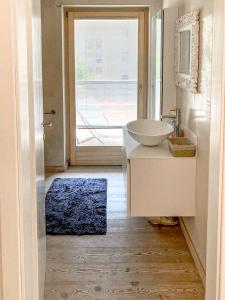 a bathroom with a sink and a mirror and a window at Elegante appartamento [Trento centro] Carpe Diem in Trento