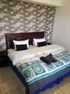 un letto con un orsacchiotto sopra di esso di Dolphin Point B&B ad Amanzimtoti