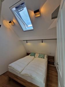 a bedroom with a bed with a skylight at Marienhof Ferienwohnungen in Geisfeld