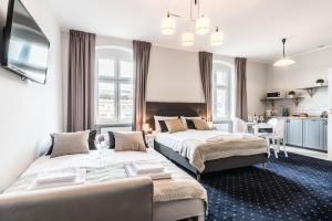a hotel room with two beds and a kitchen at SERENITY Aparthotels - Old Town Poznan by Friendly Apartments in Poznań