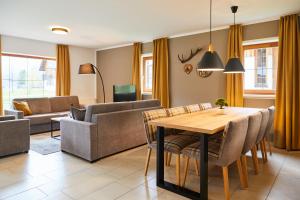 a living room with a table and chairs at Dormio Resort Obertraun in Obertraun +29 photos