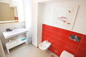 a bathroom with a toilet and a sink and red tiles at Le Camere del Tappezziere in Sant'Agnello