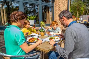 a group of people sitting at a table eating food at EuroParcs Hoge Kempen in Zutendaal +26 photos