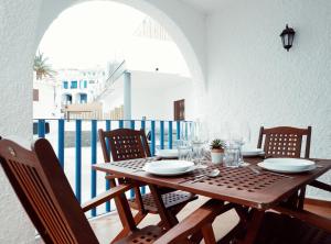 a wooden table with plates and glasses on a balcony at Casa Iqui in San José