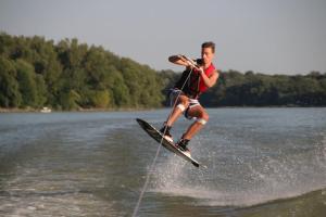un homme pratiquant le ski nautique sur une masse d'eau dans l'établissement Hausboat Vlnka, à Bratislava