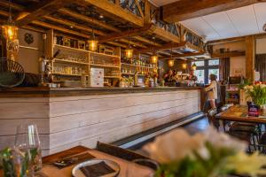 a restaurant with a bar with people in the background at EuroParcs Hoge Kempen in Zutendaal