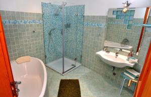 y baño con ducha y lavamanos. en Királyszéke Apartman, en Eger