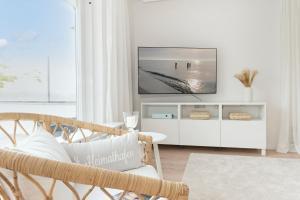 uma sala de estar com televisão num armário branco em AussichtsReich em Eutin