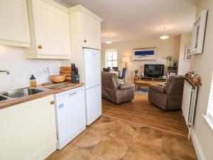 a kitchen with white cabinets and a living room at Selah in Downpatrick