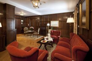 Una sala de estar con sillas rojas y una mesa. en Parador de Ribadeo, en Ribadeo