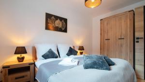 a bedroom with a bed with blue pillows at Spokojna, Sun & Snow in Wisła