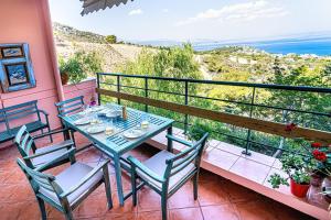 a table and chairs on a balcony with a view of the ocean at Vista sul Mare Loutra Oreas Elenis in Loutra Oraias Elenis  +78 photos