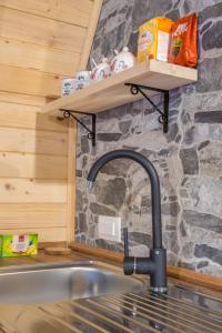 a kitchen sink with a faucet next to a stone wall at Mountain Houses Emilija in Žabljak +99 photos