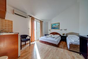 a hotel room with two beds and a television at Porta Volta Apartments in Becici
