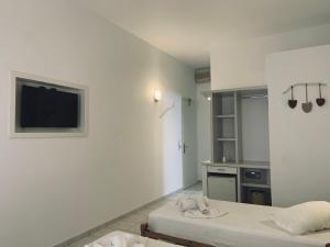 Habitación con 2 camas y TV en la pared. en Hotel Aegeon en Mylopotas