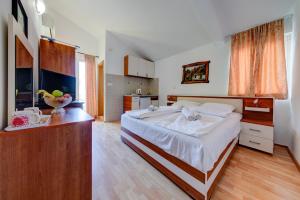 een slaapkamer met een groot bed en een keuken bij Porta Volta Apartments in Becici +25 foto's