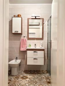 uma casa de banho com um lavatório, um WC e um espelho. em Apartman Jelena em Trebinje