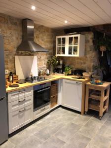 a kitchen with white cabinets and a stove top oven at Gites Graines du Jura in Chille