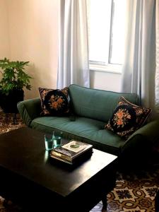 a living room with a green couch and a coffee table at Lulia in Jerusalem