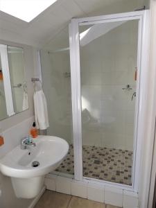 Un baño blanco con ducha y lavabo. en 83 @ The Dunes, en Plettenberg Bay