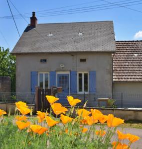 una casa con un campo de flores amarillas delante de ella en Chez Daniel, en Vauclaix