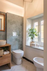 a bathroom with a toilet and a sink and a mirror at Ensemble rooms di Vayadù in Alassio