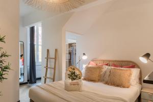 a bedroom with a bed with pillows and a chandelier at Ensemble rooms di Vayadù in Alassio