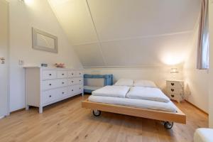 1 dormitorio blanco con 1 cama y vestidor en Buitenplaats 62 Callantsoog, en Callantsoog