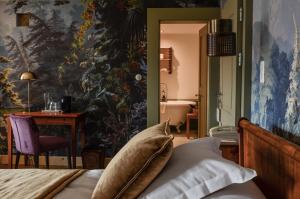 ein Schlafzimmer mit einem Bett und einem Wandgemälde in der Unterkunft Hôtel Bella Tola & SPA in Saint-Luc