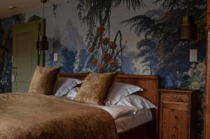 a bedroom with a bed with a painting on the wall at Hôtel Bella Tola & SPA in Saint-Luc