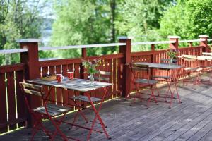 zwei Tische und Stühle auf einer Holzterrasse in der Unterkunft Nordic Refuge B&B in Fröskog