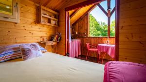 1 dormitorio en una cabaña de madera con 1 cama y 1 mesa en Robinzonski turizam "Robin` s Hood" en Skrad