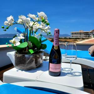 una botella de vino en una mesa con un jarrón de flores en Villa Mar Felostal en Palma de Mallorca