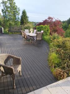 una terraza de madera con mesa y sillas. en Solstua, en Sandefjord