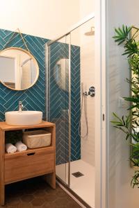 a bathroom with a shower with a sink and a mirror at Ensemble rooms di Vayadù in Alassio