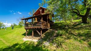 a tree house on a hill in a field at Robinzonski turizam "Robin` s Hood" in Skrad