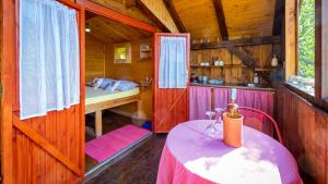 Zimmer mit einem Tisch und einem Bett in einer Hütte in der Unterkunft Robinzonski turizam "Robin` s Hood" in Skrad