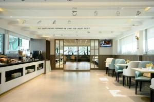 曼谷Centre Point Plus Hotel Pratunam的一间带桌椅的餐厅和一个大堂