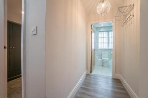 a hallway with a bathroom with a toilet and a chandelier at The Queens Arms Apartments in Liverpool +85 photos