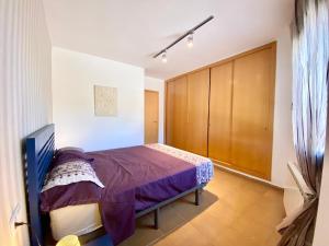a bedroom with a bed and a wooden cabinet at Hauzify I Apartament Forques in Sant Feliu de Guíxols