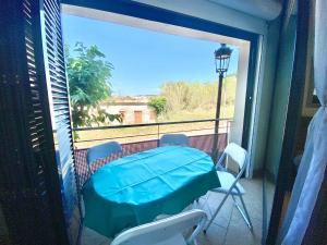 a balcony with a table and chairs and a window at Hauzify I Apartament Forques in Sant Feliu de Guíxols