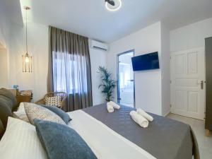 a bedroom with a bed with pillows on it at CAMARA SUITE with Jacuzzzi in Poros