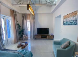 a living room with a couch and a television at CAMARA SUITE with Jacuzzzi in Poros