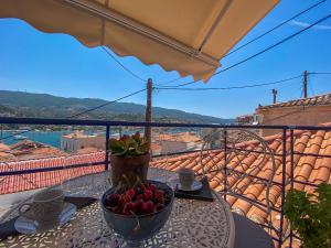 a table with a bowl of fruit on a balcony at CAMARA SUITE with Jacuzzzi in Poros