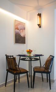 a dining room table with two chairs and a painting at CAMARA SUITE with Jacuzzzi in Poros