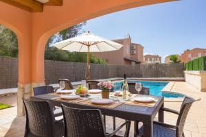 a table with an umbrella on a patio at Villa Martinur by Villa Plus in Cala en Blanes