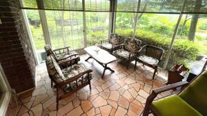 a screened in porch with chairs and a table at Morinouta in Nikko