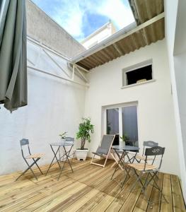 eine Terrasse mit Stühlen, einem Tisch und einem Fenster in der Unterkunft Chambre Aliénor d'Aquitaine in Bordeaux